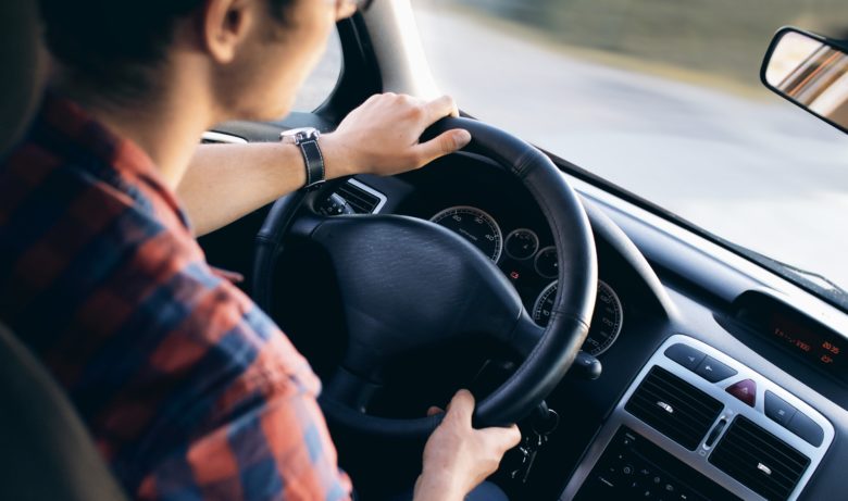 Man behind the wheel of car with auto insurance